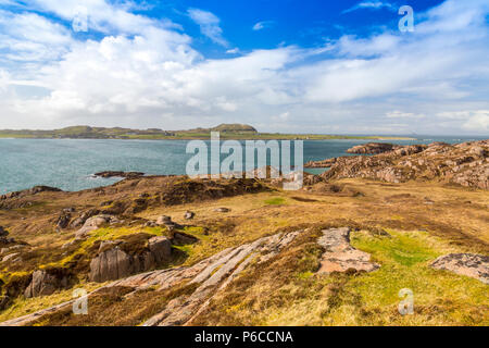 Guardando attraverso il suono di Iona dal granito rosso sopra rocce Fionnphort sul Ross di Mull, Argyll and Bute, Scotland, Regno Unito Foto Stock