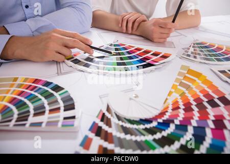 Due architetti mano scegliendo il colore da vari campioni colorati su Cianografia Foto Stock