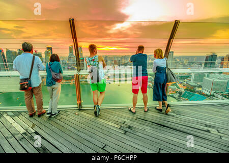 Singapore - 3 Maggio 2018: turisti in cerca viste panoramiche dal ponte di osservazione Skypark di Marina Bay sands hotel e casinò. Il quartiere finanziario skyline sullo sfondo. Sunset shot. Foto Stock