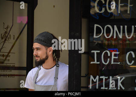 Cameriere sullo sportello, Brick Lane, East London, Englamd, Regno Unito Foto Stock