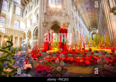 Coristi dalla Cattedrale di Ely in Cambridgeshire facendo qualche last minute innaffiamento di fiori in questo anni Flower Festival tenutosi all interno della cattedrale. Un otto metri di caleidoscopio di blumi sotto la Cattedrale di Ely la famosa torre ottagonale in Cambridgeshire è uno dei momenti salienti del Festival dei Fiori che si apre oggi (giovedì). Più di 100 specialista floral designer hanno trascorso giorni creando la presenta per il caleidoscopio di vita evento che includono circa 50.000 blumi. La 100 presenta spettacolari includono un arco floreale la lunghezza di Ely la navata. Foto Stock