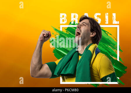 Calcio brasiliano player, celebrando su sfondo giallo con copia spazio. Foto Stock