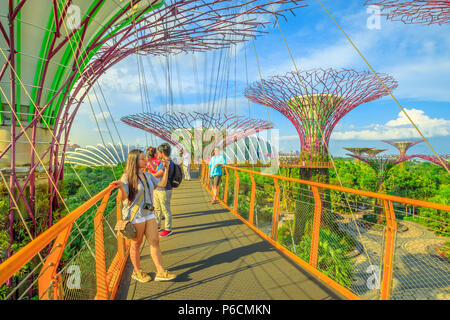 Singapore - Aprile 29, 2018: asian tourist prende selfie con smart phone mentre camminando sul ponte sopraelevato o OCBC Skyway di Supertree Grove in giardini dalla baia di Marina Bay a Singapore. Foto Stock