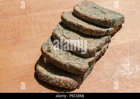 Fette di muffa di grani closeup il pane sulla tavola di legno sfondo Foto Stock