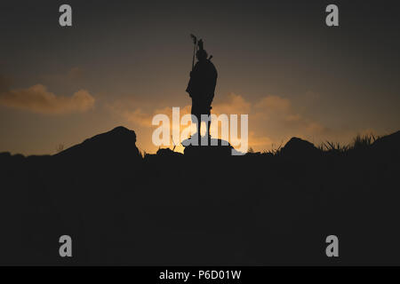 Silhouette di uomo Masai permanente sulla roccia Foto Stock