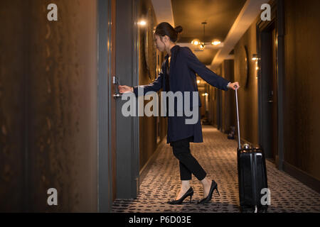 Donna di entrare nella camera di albergo Foto Stock