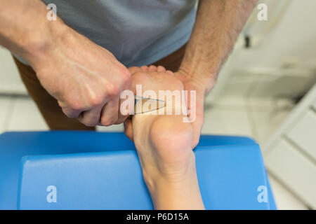 Fisioterapista dando massaggio delle gambe per donna Foto Stock