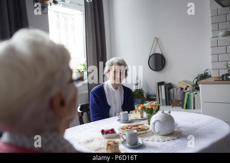 Senior amici strega interagenti tra loro pur avendo prima colazione Foto Stock