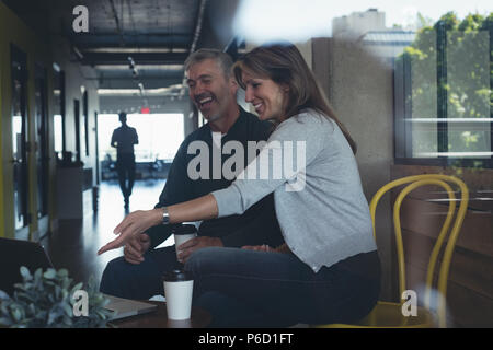 La gente di affari discutendo su laptop Foto Stock