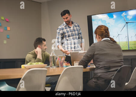 Colleghi di lavoro interagire gli uni con gli altri nella sala riunioni Foto Stock