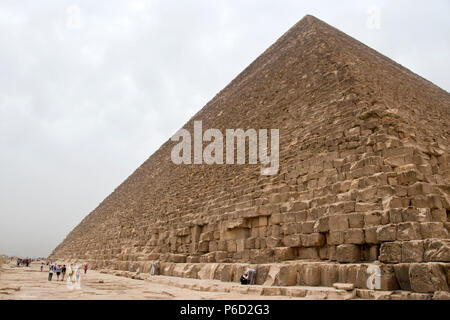 I turisti a piedi intorno alla base della Grande Piramide di Giza (piramide di Khufu, piramide di Cheope) di Giza in Egitto. Foto Stock