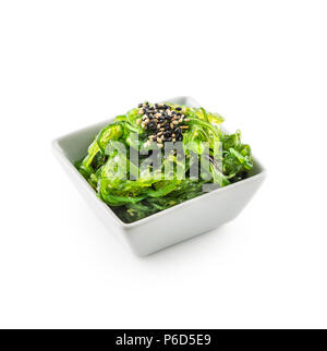 Wakame con insalata di alghe e semi di sesamo isolato su bianco. Foto Stock