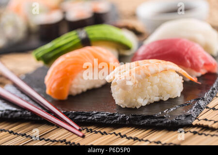Set di nigiri sushi sulla scheda di ardesia con bacchette. Foto Stock