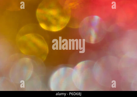 Abstract irridescent rossa e dorata sfondo bokeh, incandescente cerchi. Foto Stock