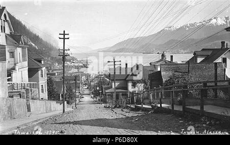 . Inglese: vista giù per una strada in salita di Juneau, ca. 1912 . Inglese: didascalia sull'immagine: Juneau in Alaska, PH Coll 247.426 situato sulla terraferma di sud-est Alaska Juneau è stato costruito nel cuore del passaggio interno lungo il canale Gastineau. La zona era un fish camp per gli indigeni Tlingit indiani. Nel 1880, quasi 20 anni prima dell'oro precipita il Klondike e nome, Joe Juneau e Richard Harris era stato portato a Gold Creek da Chief Kowee della tribù Auk. Essi hanno trovato madre depositi di lode a monte, puntato le loro rivendicazioni di data mining e sviluppato un 160 acri città incorporati hanno chiamato Harrisburg, Foto Stock