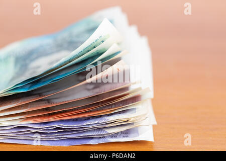 Pila di varie banca britannica note su un tavolo Foto Stock