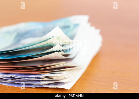 Pila di varie banca britannica note su un tavolo Foto Stock