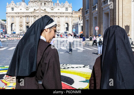 Roma, Italia. In occasione della festa di San Pietro e San Paolo, i due santi patroni di Roma, ritorna la storica Infiorata, spettacolare tappeto di fiori che scende in via della conciliazione e verso il Tevere. Due suore che guardano il tappeto di fiori. Roma, Italia, Europa, Unione europea, UE. Credit: Glenstar/Alamy Live News Foto Stock