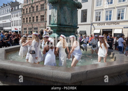 Copenaghen, Danimarca. 29 giugno 2018. Gli studenti danesi festeggiano la loro laurea di scuola superiore / grammer e fanno un tuffo. Un ballo intorno e un tuffo o un tuffo nell'acqua fredda della fontana della cicogna (Storkespringvandet) sulla strada pedonale, Stroeget, è un elemento tradizionale il giorno della celebrazione per gli allievi laureati nella parte più grande di Copenhagen. Spesso fa parte del lungo, faticoso e vivace tour in camion che visita la casa di ogni studente per un rinfresco. Credit: Niels Quist/Alamy Live News Foto Stock