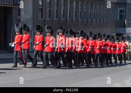 Glasgow, Scotland, Regno Unito. Il 30 giugno, 2018. Le guardie rosse che indossano tuniche, pantaloni neri e bearskin hats marching durante le Forze Armate giorno. La sfilata di un corteo attraverso il centro della città da Holland Street a George Square è guidato dal Royal Marine Band e include il servizio militare, cadetti, le organizzazioni per la gioventù e il veterano associazioni. Credito: Berretto Alamy/Live News Foto Stock