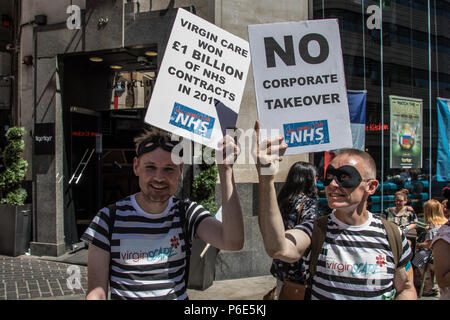 Londra, Regno Unito. Il 30 giugno, 2018. Due uomini mascherati vestiti come carcerati/ ladri con 'Virgin spaventare' (Vergine Care) sulla loro t-shirt tenere alto il loro cartelloni per la fotocamera. Con il NHS 70 anni quest'anno, migliaia hanno marciato attraverso il centro di Londra in un rally nazionale per mostrare il supporto per il servizio e la richiesta di maggiori finanziamenti da parte del governo. David Rowe/Alamy Live News Foto Stock