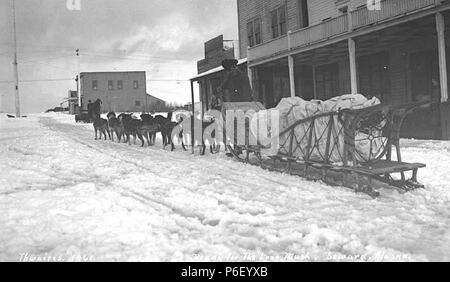 . Inglese: slitta trainata da cani team e piloti, con carico, Seward, ca. 1914 . Inglese: didascalia sull'immagine: Pronto per il lungo una sorta di polenta, Seward, Alaska PH Coll 247.387 prima della formazione di Sled Dog racing come formale dello sport, slitte trainate da cani sono stati allevati e utilizzato dai popoli nativi delle regioni polari del mondo nella loro vita quotidiana per la sopravvivenza in climi rigorosi. Due cani comunemente impiegati in slittino sono Alaskan Malamute e Siberian Husky. Queste due razze ha avuto origini diverse e usi. Alaskan Malamute originata da un gruppo di persone eschimese noto come Mahlemiut. I cani di quel tempo sono stati ver Foto Stock