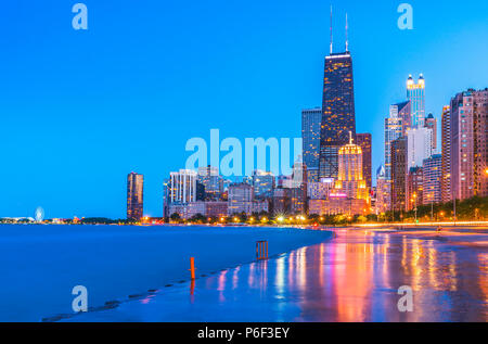 Sullo skyline di Chicago al tramonto con il cielo nuvoloso e riflesso nell'acqua. Foto Stock