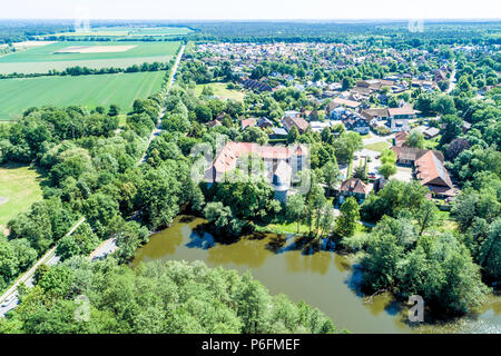 Vista aerea di un villaggio tedesco con una piccola foresta, un laghetto e una moated il castello in primo piano, nei pressi di Wolfsburg Foto Stock