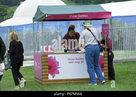 Vista posteriore dell'uomo, acquisto Visualizza guida da donna che lavorano sui chioschi dal cancello di ingresso alla showground, RHS Chatsworth Flower Show, Derbyshire, Inghilterra, Regno Unito. Foto Stock