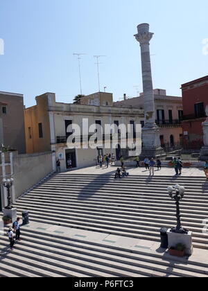 Brindisi, Italia - 30 Aprile 2018: Colonne terminali della antica Via Appia che inizia a Roma e termina a Brindisi (Italia) e i turisti in visita Foto Stock