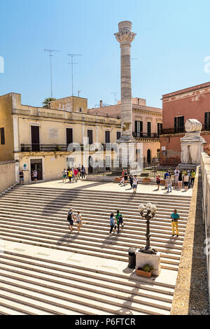 Brindisi, Italia - 30 Aprile 2018: Colonne terminali della antica Via Appia che inizia a Roma e termina a Brindisi (Italia) e i turisti in visita Foto Stock