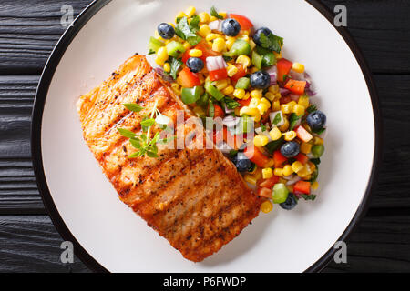 Bistecca alla griglia salmone con pepe, mais, mirtillo e insalata di onion closeup su lastra sul tavolo. parte superiore orizzontale vista da sopra Foto Stock