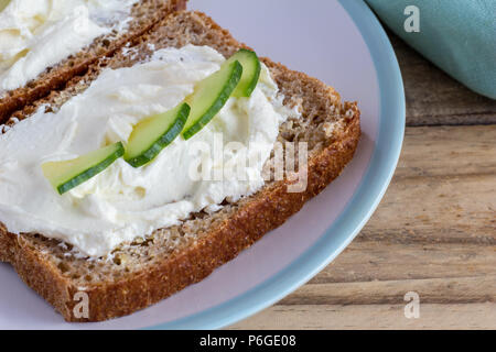 Crema di formaggio cottage sulla fetta di tutta marrone pane di grano vicino fino Foto Stock