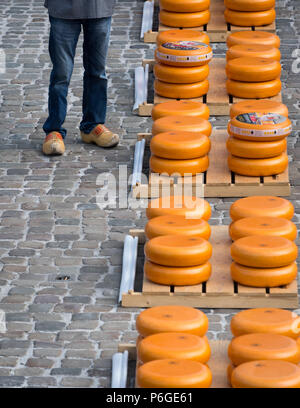 Tradizionali olandesi zoccoli e formaggi impilati al formaggio Gouda mercato, Paesi Bassi Foto Stock