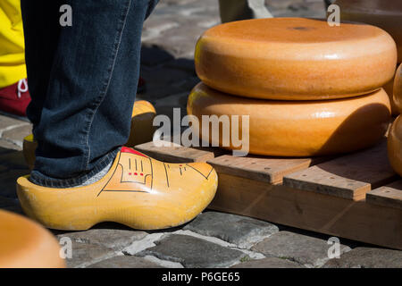 Tradizionali olandesi zoccoli e formaggi impilati al formaggio Gouda mercato, Paesi Bassi Foto Stock