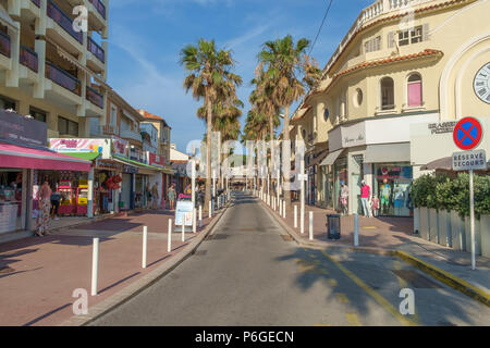 Negozi, ristoranti e palme lungo la passeggiata a mare di Juan les Pins, Antibes, Francia. Foto Stock