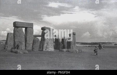 Degli anni Cinquanta, foto storiche di visitatori a Stonehenge, Wiltshire, Inghilterra, famosa in tutto il mondo momument preistorico. In questa epoca di visitatori all'antica anello di pietre permanente poteva camminare tra di loro è abbastanza liberamente, ma questo è stato arrestato nel 1977 come un risultato di "erosione" e ora è qualcosa che è consentito solo sulla cosiddetta " speciali visite accesso'. Foto Stock