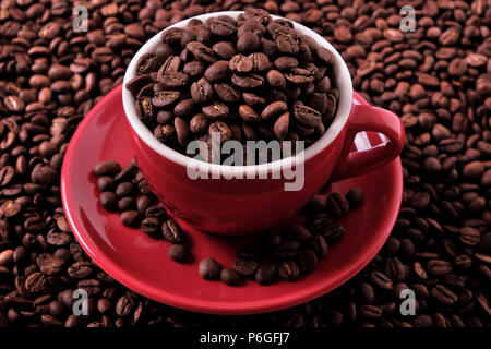 Caffè rosso tazza riempita con fagioli arrosto closeup Foto Stock