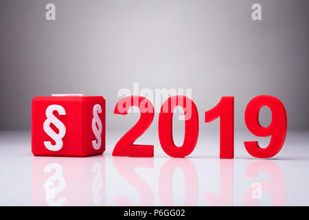 Il cubo rosso con simbolo di paragrafo oltre 2019 su sfondo riflettente Foto Stock