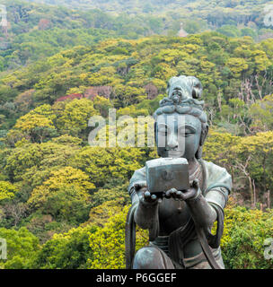 Buddhistic statua della femmina offrendo dono a Tian Tan Buddha di Ngong Ping, Lantau Island, Hong Kong. Foto Stock