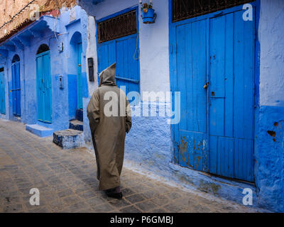 CHEFCHAOUEN, Marocco - circa aprile 2017: marocchina uomo a camminare per le strade di Chefchaouen indossando un djellaba tradizionale Foto Stock