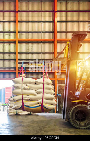 Carrello di movimentazione dello zucchero bianco sacchi per il ripieno in contenitori al di fuori di un magazzino. Distribuzione, Logistica Import Export, concetto di magazzino. Foto Stock