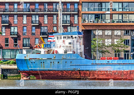 Rotterdam, Paesi Bassi, 31 Maggio 2018: una un po' arrugginite imbarcazione è ormeggiata in banchina di Lloydpier neighbouhood residenziale
