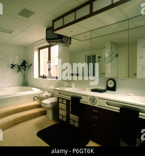Armadi speculare al di sopra di lavabi doppi in nero + bianco unità vanity in bagno bianco con moquette passi per vasca da bagno Foto Stock