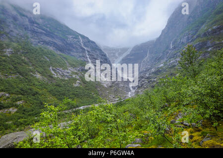 Glacier Kjenndalsbreen nella valle Loendal, Loen, Norvegia, lingua del ghiacciaio e cascata nella nebbia Foto Stock