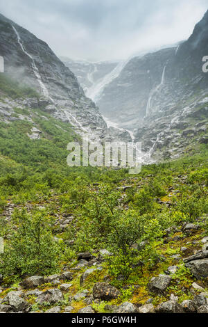 Glacier Kjenndalsbreen nella valle Loendal, Loen, Norvegia, lingua del ghiacciaio e cascata nella nebbia Foto Stock