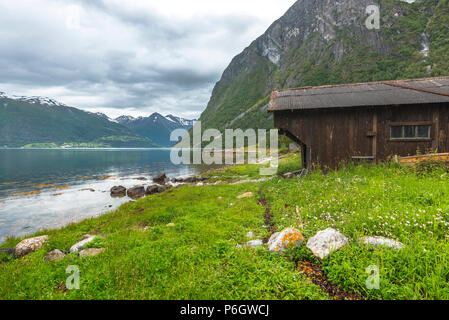Vecchio boathouse con panorama del fiordo, Norvegia, Norddalsfjorden o Storfjorden vicino a Eidsdal e eagle road da Geiranger Foto Stock