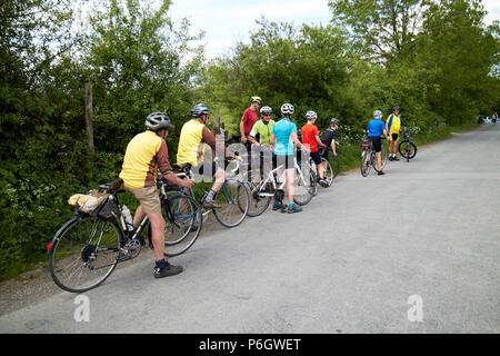 Un gruppo di ciclisti su una gita in bici su un vicolo del paese nel distretto del lago Cumbria Inghilterra England Regno Unito Foto Stock
