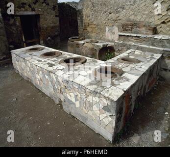 L'Italia. Pompei. Rivestito di marmo Thermopolium di contatore. Situato tra Cardo V e inferiore Decumanu. Campania. Foto Stock