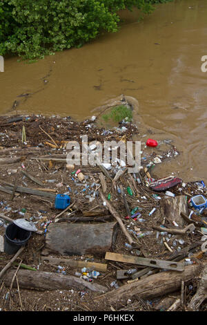 Tutti i tipi di umana prodotta dai detriti, come bottiglie di plastica e rami, legno e fango intasare e inquinare un fiume dopo un allagamento Foto Stock